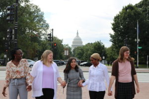 Five NETWORK Associates - young adults - stand in front of the U.S. Capitol Dome