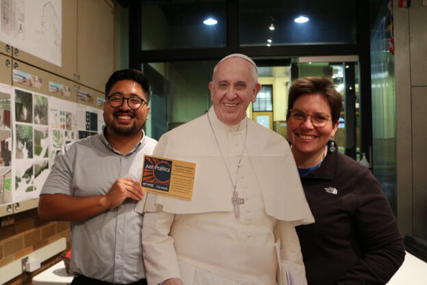 Colin Martinez Longmore and Sr. Eilis McCulloh, HM, of the NETWORK Grassroots Mobilization Team and co-hosts of the Just Politics podcast, stand with a cutout of Pope Francis at University of Detroit Mercy on Oct. 12, 2022, on NETWORK's Pope Francis Voter Tour.